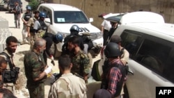 FILE - U.N. arms experts and opposition fighters are seen in Damascus' eastern Ghouta suburb on Aug. 29, 2013.