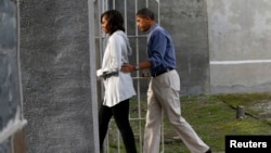 U.S. President Barack Obama and first lady Michelle Obama tour the jail where Nelson Mandela was imprisoned on Robben Island, near Cape Town, June 30, 2013. 