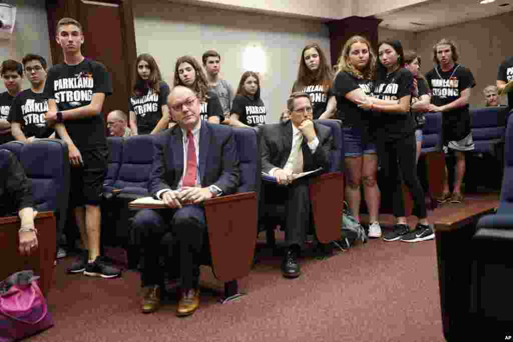 Lobbyists and attorneys listen as student survivors from Marjory Stoneman Douglas High School, where more than a dozen students and faculty were killed in a mass shooting on Wednesday, interrupt a house legislative committee hearing, to challenge lawmaker