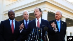 Senate Finance Committee member Sen. Patrick Toomey, R-Pa., second from right, with, from left, Sens. Tim Scott, R-S.C., John Cornyn, R-Texas,, and Chairman Orrin Hatch, R-Utah, speaks to reporters following a meeting with President Donald Trump at the White House in Washington, Nov. 27, 2017.