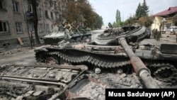 GEORGIA -- Russian soldiers ride atop an armoured vehicle through a street in Tskhinvali, capital of Georgian breakaway enclave of South Ossetia, August 12, 2008