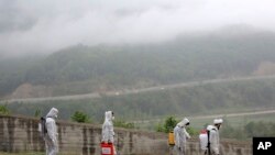 FILE - Volunteers wearing protective clothing, take part in disinfecting a village during the coronavirus outbreak, in the outskirts of the city of Ghaemshahr, in north of Iran, April 29, 2020.
