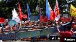 Demonstrators display a part of a fishing boat with anti-China protest signs during a rally by different activist groups over the South China Sea disputes, outside the Chinese Consulate in Makati City, Metro Manila, Philippines, July 12, 2016.