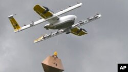 In this Tuesday, Aug, 7, 2018, photo a Wing Hummingbird drone carries a package of ice cream and popsicles as it leaves its launch site during a delivery flight demonstration in Blacksburg, Va. (Michael Shroyer via AP)