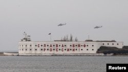 Helikopter penyerang, yang diperkirakan milik Rusia, terbang di atas markas militer Rusia di Sevastopol (7/3).