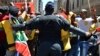 FILE - A police officer tries to control ANC supporters as they attempt to confront members of the opposition Democratic Alliance party marching in central Johannesburg, February 2014.