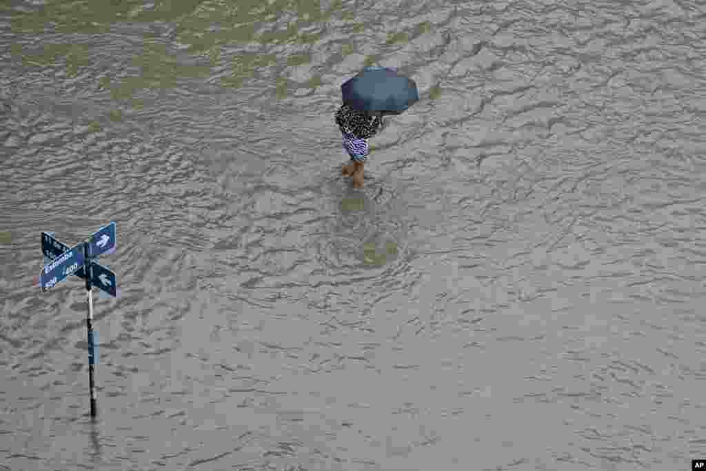 A person wades through a flooded street after a storm in Bahia Blanca, Argentina.