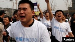 សមាជិក​គ្រួសារ​អ្នក​ដំណើរ​លើ​យន្តហោះ​ម៉ាឡេស៊ី MH370 យំ​នៅ​ពេល​ស្រែក​ពាក្យ​ស្លោក​ក្នុង​អំឡុង​ពេល​តវ៉ា​នៅ​មុខ​ស្ថានទូត​ម៉ាឡេស៊ី​នៅ​ទី​ក្រុង​ប៉េកាំង កាល​ពី​ថ្ងៃ​អង្គារ​ទី​២៥ ខែ​មីនា ឆ្នាំ​២០១៤។