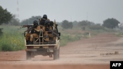 FILE - Burkinabe gendarmes patrol near military barracks in Ouagadougou, Sept. 29, 2015. Burkina Faso security forces launched a massive manhunt on April 27, 2021, after an attack on an anti-poaching patrol.