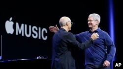 CEO Apple Tim Cook (kanan) merangkul salah satu pendiri Beats by Dre dan pegawai Apple, produser musik Jimmy Iovine dalam sebuah konferensi Apple di San Francisco, Juni 2015. (AP/Jeff Chiu)