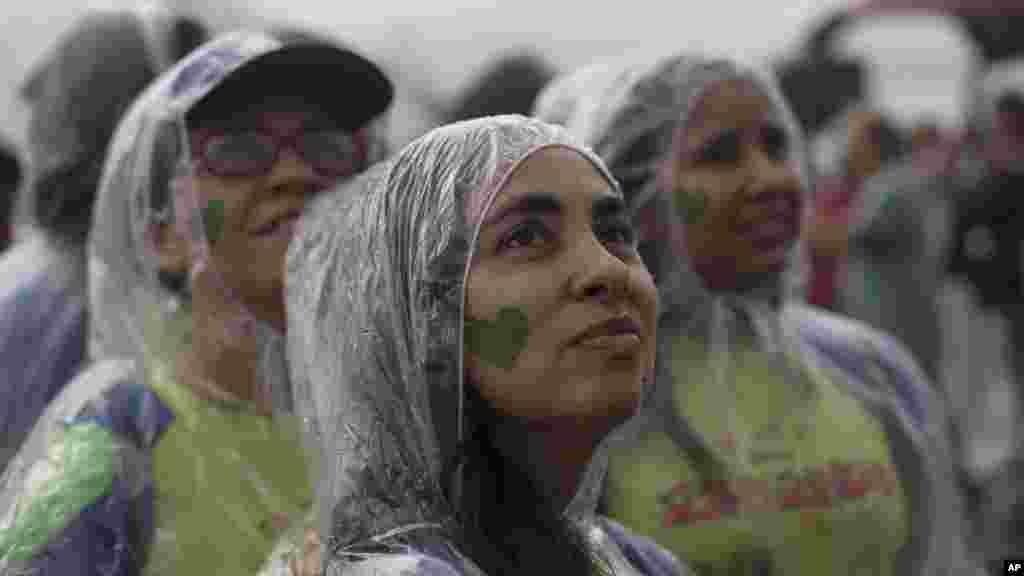 Para demonstran Pawai Iklim Rakyat di bawah hujan di pantai Ipanema,&nbsp;Rio de Janeiro, Brazil (21/9).&nbsp;(AP/Silvia Izquierdo) 