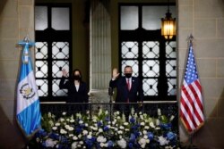 U.S. Vice President Kamala Harris and Guatemala's President Alejandro Giammattei wave as they pose for a photo on a balcony at the Palacio Nacional de la Cultura, in Guatemala City, Guatemala, June 7, 2021.