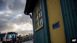 FILE - A farmer drives a tractor past an old customs post at the border between with the Republic of Ireland and Pettigo, Northern Ireland, Dec. 23, 2019.