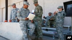 Arizona National Guard soldiers receive their reporting paperwork prior to deployment to the Mexico border at the Papago Park Military Reservation in Phoenix, April 9, 2018.