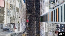 Suasana unjuk rasa menunjukkan ribuan orag berpawai melalui sebuah jalan saat mereka mengambil bagian dalam sebuah pawai terhadap RUU ekstradisi yang kontroversial di Hong Kong, 16 Juni 2019