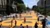 With the Washington Monument in the background people walk on the street leading to the White House after the words Black Lives Matter were painted on it by city workers and activists Friday, June 5, 2020, in Washington. (AP Photo/Manuel Balce Ceneta)