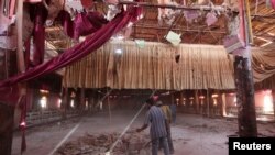 Men remove rubble from a damaged wedding hall after a suicide attack on a Kurdish wedding in Hasaka city, Syria, Oct. 4, 2016. 