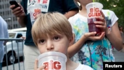 Anak-anak di New York minum minuman soda berukuran besar (foto: dok). Pengadilan banding menolak proposal Walikota Bloomberg melarang minuman soda ukuran besar. 