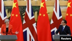FILE - British Prime Minister Theresa May speaks during a joint press conference with Chinese Premier Li Keqiang at the Great Hall of the People in Beijing, China, Jan. 31, 2018. 