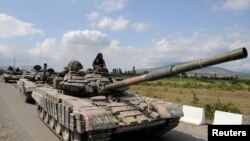 FILE - A Georgian tank moves along a road near the city of Tskhinvali, 100 km (62 miles) from Tbilisi, Aug. 8, 2008. 