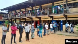 People wait in line for the opening of a polling office during the presidential election in Libreville, Gabon, on Aug. 26, 2023.