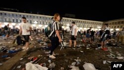Pendukung Juventus mencari barang milik pribadi di Piazza San Carlo setelah kepanikan yang timbul di zona pendukung dimana ribuan pendukung Juventus menonton pertandingan final Liga Champions UEFA antara Juventus dan Real Madrid di layar raksasa di Turin, Italia, tanggal 3 Juni 2017 (foto: AFP PHOTO/MASSIMO PINCA)