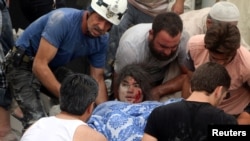 Men carry an injured girl after an airstrike on Aleppo's rebel-held Kadi Askar area, Syria, July 8, 2016.