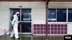 Seorang pekerja melakukan 'dekontaminasi' sebuah taman kanak-kanak di Minami-Soma (sekitar 20 kilometer) dari PLTN Fukushima Dai-ichi (18/8). Studi baru menunjukkan radiasi tinggi masih ditemukan hingga 60 kilometer dari PLTN yang bocor.