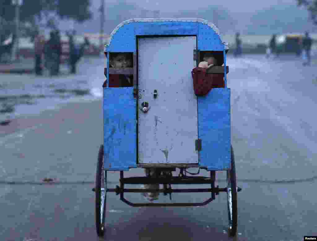 Murid-murid berangkat ke sekolah dengan naik &#39;rickshaw&#39; (sejenis becak) pada suatu pagi yang dingin di kota tua Delhi (Old Delhi), di India.