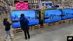 Jen jan k ap fe acha gade gwo ekran televizyon nan depo Costco nan Denver, Colorado, 19 Desanm 2024. 