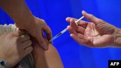 រូបឯកសារ៖ ស្ត្រីម្នាក់ ទទួល​ការចាក់​វ៉ាក់សាំង Pfizer-BioNTech ការពារ​ជំងឺ​កូវីដ១៩ នៅ​មណ្ឌល​សុខភាព​មួយ​នៅ​ទីក្រុង Cardiff កាលពី​ថ្ងៃទី៨ ខែធ្នូ ឆ្នាំ២០២០ នៅ​ពេល​ដែល​ចក្រភព​អង់គ្លេស ចាប់ផ្តើម​កម្មវិធី​ចាក់វ៉ាក់សាំង​ធំ​បំផុត​មិន​ធ្លាប់​មាន។