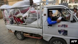 Yemenis deliver donations collected from citizens to help displaced people who fled the war-torn port city of Hodeida at a school used as a camp for displaced people in the capital Sanaa on June 22, 2018.