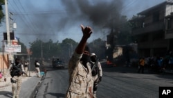 Police clear burning tire road blocks set by protesters upset with growing violence in the Lalue neighborhood of Port-au-Prince, Haiti, July 14, 2021.