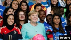 La chancelière allemande Angela Merkel et l’équipe féminine internationale de football du projet "Discover Football", à la chancellerie à Berlin, en Allemagne, le 1er Septembre 2016. REUTERS / Hannibal Hanschke - RTX2NT1K