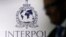 FILE - A man passes an Interpol logo in Singapore.