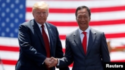 ARSIP – Presiden AS, Donald Trump, berjabat tangan dengan Presdir Foxconn, Terry Gou, dalam pembukaan lokasi industri baru Foxconn di Mount Pleasant, Wisconsin, AS, 28 Juni 2018 (foto: Reuters/Kevin Lamarque/Foto Arsip)