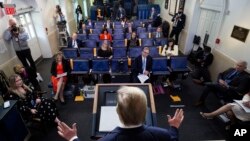 Reporters are seen complying with social distancing norms as President Donald Trump speaks about the coronavirus in the James Brady Press Briefing Room at the White House, April 13, 2020, in Washington. 