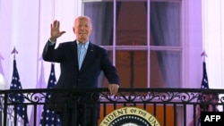 Presiden AS Joe Biden melambaikan tangan dari balkon di Gedung Putih, saat ia tiba untuk menyaksikan pesta kembang api menyambut Hari Kemerdekaan AS di Washington, DC, pada 4 Juli 2024. (Foto: AFP/Mandel Ngan)