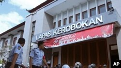 Para petugas penjara berjalan di depan pintu masuk gedung penjara Kerobokan, Bali, 19 Juni 2017. (AP Photo/Firdia Lisnawati).
