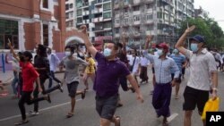 Anti-coup protesters display the three-finger sign of resistance during a flash mob on June 3, 2021, in Yangon, Myanmar.