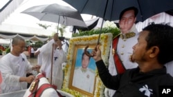 សាច់ញាតិ​លោកប៉ែន សុវណ្ណ ឈរ​កាន់​ឆ័ត្រ​បាំង​ភ្លៀង​លើ​រូប​ថត​សព​លោក ប៉ែន សុវណ្ណ អតីត​នាយករ​ដ្ឋ​មន្ត្រី​កម្ពុជា នៅ​ក្នុង​អំឡុង​ពេល​បូជា​សព នៅ​វត្ត​ឫស្សីសាញ់នៅ​ជាយ​ក្រុង​ភ្នំពេញ កាលពីថ្ងៃអាទិត្យ ទី៦ ខែ​វិច្ឆិកា ឆ្នាំ​២០១៦។