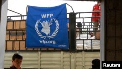 រូបឯកសារ៖ ក្មេង​ប្រុស​ម្នាក់​ឈរ​នៅ​មុខ​រថយន្ត​ដឹក​ស្បៀង​អាហារ របស់​កម្មវិធី​ស្បៀង​អាហារ​ពិភពលោក​នៅ​ថ្ងៃទី២៩ ខែមីនា ឆ្នាំ២០១៤។