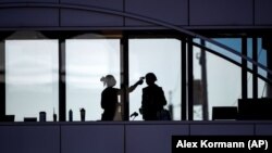 In this Friday, April 10, 2020, file photo, a healthcare worker takes the temperature of a visitor to Essentia Health who was crossing over a skywalk bridge from the adjoining parking deck, in Duluth, Minn. (Alex Kormann/Star Tribune via AP, File)