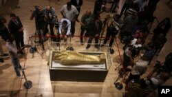Para jurnalis berkumpul di sekitar peti mati emas yang pernah digunakan untuk menyimpan mumi Nedjemankh, seorang imam di Zaman Ptolemeus sekitar 2.000 tahun yang lalu, di Museum Nasional Peradaban Mesir, di Kairo, Mesir, Selasa, 1 Oktober, 2019.