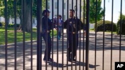 Agenti Tajne službe podižu dečaka koji se provukao kroz ogradu Bele kuće na Aveniji Pensilvanija u Vašingtonu, 18. aprila 2023. (Foto AP/Nancy Benac) 