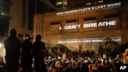 FILE - In this Saturday, July 25, 2020, file photo, the words "I can't breathe" are flashed on a wall during a Black Lives Matter protest in Portland, Ore. State legislatures across the U.S. are pushing an array of policing reforms after the…