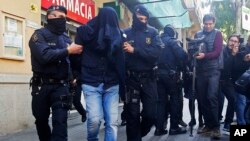 Des policiers emmènent un homme non identifié, à Barcelone, Espagne, 25 avril 2017.
