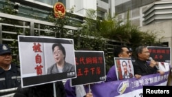 资料照：香港抗议者在北京驻香港机构中联办前手举铜锣湾书店失踪老板桂民海的照片。 （2016年1月19日）