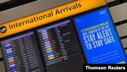 FILE PHOTO: A public health campaign message is displayed on an arrivals information board at Heathrow Airport, following the outbreak of the coronavirus disease (COVID-19), London, Britain