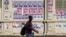 A man offering nail polish services walks in front of electoral posters outside the Municipal Market in Maputo, Mozambique, on Oct. 04, 2024. Voters head to the polls on Oct. 9, 2024 to elect their next president. 